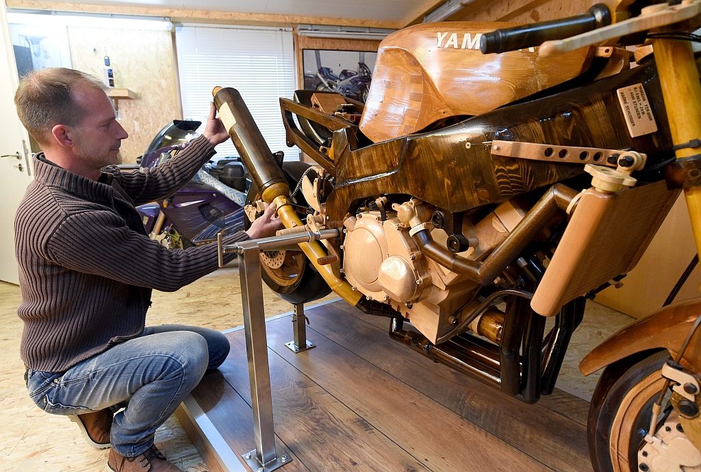 epa04745581 A picture made available on 13 May 2015 shows German Andre Schlosser working on a wooden motorbike, which he has been building for the last twelve years, in his garage in Nienborstel, Germany, 30 April 2015. Because his wife did not want him to put his old Yamaha motorbike in the living room, he made a copy of the Yamaha FZR 600 from wood.  EPA/CARSTEN REHDER