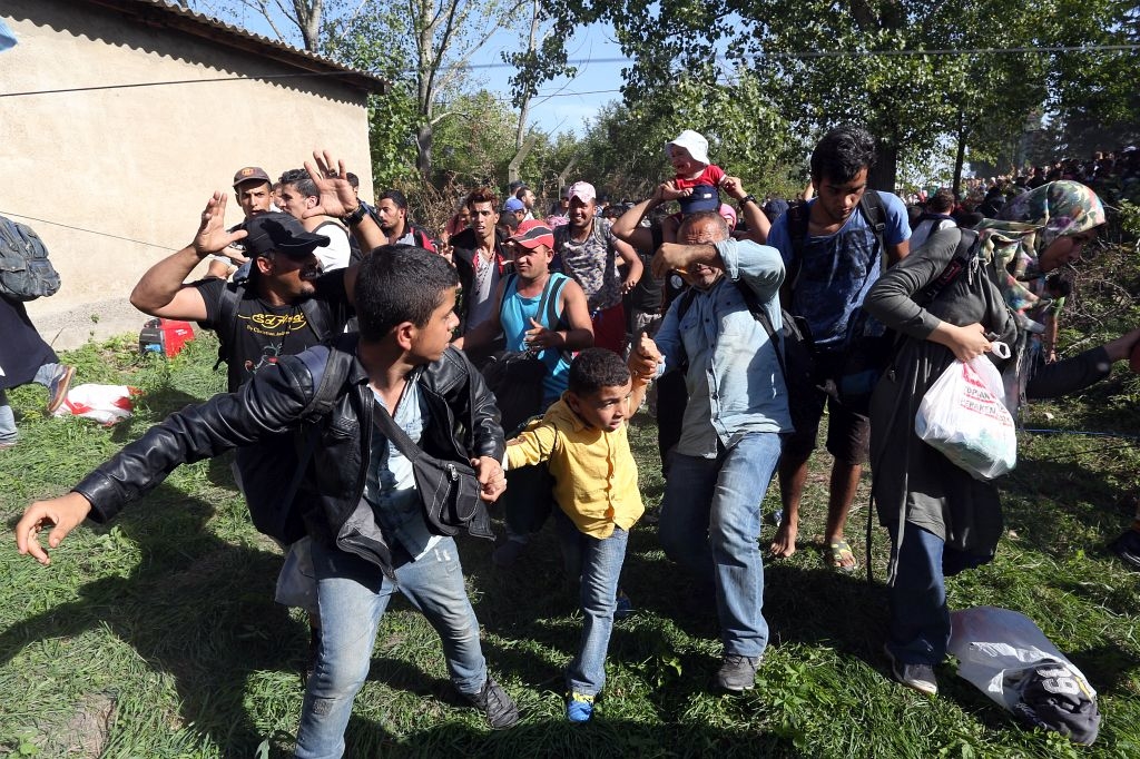 Tovarnik, 17.09.2015 - Sirijske izbjeglice koje cijeli dan stoje na suncu na eljeznièkoj stanici u Tovarniku, probile su policijsku barikadu i uputile se prema autobusima i pjeice prema Zagrebu. foto HINA/ Damir SENÈAR /ds