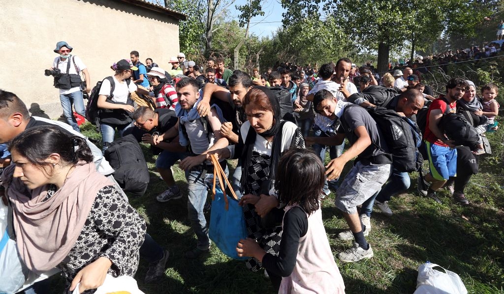 Tovarnik, 17.09.2015 - Sirijske izbjeglice koje cijeli dan stoje na suncu na eljeznièkoj stanici u Tovarniku, probile su policijsku barikadu i uputile se prema autobusima i pjeice prema Zagrebu. foto HINA/ Damir SENÈAR /ds