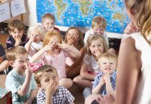 odgajateljima Montessori/Pre-School Class Listening to Teacher on Carpet