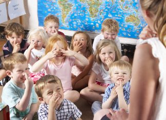 odgajateljima Montessori/Pre-School Class Listening to Teacher on Carpet