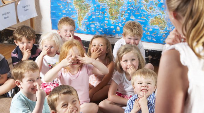 odgajateljima Montessori/Pre-School Class Listening to Teacher on Carpet